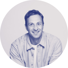 Чёрно-белая фотография. Back-end Java разработчик Денис улыбается.